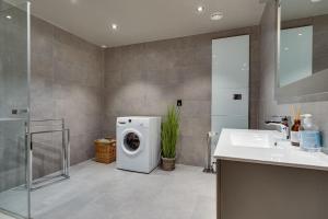 a bathroom with a washing machine and a sink at Tiltalende og romslig leilighet in Beitostøl