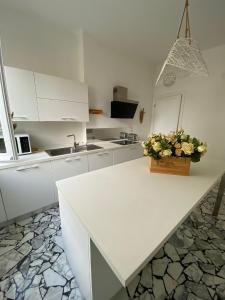 a white kitchen with a counter with flowers on it at La perla in Chiavari