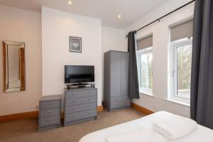 a bedroom with a bed and a tv and windows at Trafalgar Terrace in Darlington