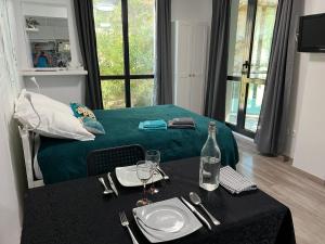Carry centre au calme في كاري-لو-رويه: غرفة مع سرير وطاولة مع زجاجة من النبيذ