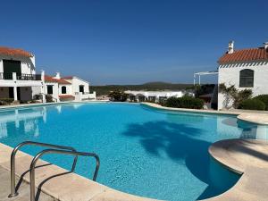 uma grande piscina com água azul numa casa em ALDEAMAR F1 by SOM Menorca em Son Parc