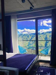Twins apartment deluxe, new gudauri في غودواري: غرفة نوم بسرير وإطلالة على جبل