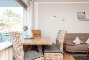 a dining room with a table and chairs and a couch at Haus Hanseatic, Wohnung 111 in Duhnen