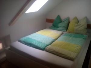 a bed with colorful sheets and pillows in a room at Ferienwohnung am Teupitzsee in Teupitz