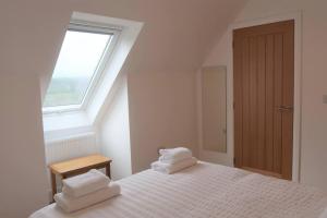 a bedroom with a bed with two towels on it at Wee Neuk in Spean Bridge