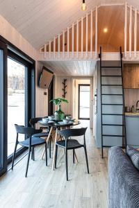 a tiny house with a dining room and a loft bed at Wynki no. 69 in Łukta