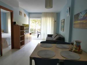 a living room with a table and a couch at S'Abanell Central Park seafront apartment in Blanes
