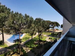 a view of a pool and trees from a balcony at S'Abanell Central Park seafront apartment in Blanes