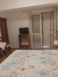 1 dormitorio con 1 cama y TV en una habitación en Villa Magnolija, en Mlini