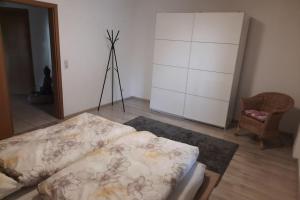 a bedroom with a bed and a dresser and a tripod at City-close oasis in the green in Deggendorf