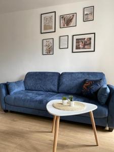 a blue couch in a living room with a table at Bresno8 in Gdańsk