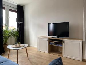 a living room with a flat screen tv on a cabinet at Bresno8 in Gdańsk