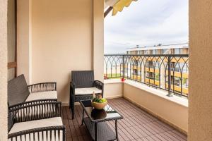 a balcony with two chairs and a table and a window at M1 Pool and Beach View Apartment in Burgas