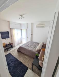 1 dormitorio con cama, sofá y TV en The Hideaway, en El Cairo