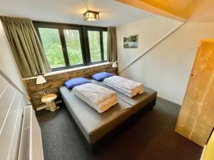 1 dormitorio con 2 camas y ventana en KempenLodge, luxe boshuis voor 8 pers, in Brabantse natuur, en Diessen