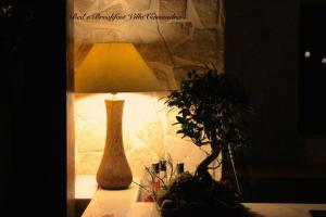 un vase assis sur une table à côté d'une lampe dans l'établissement B&B Villa Cassandra, à Castellana Grotte