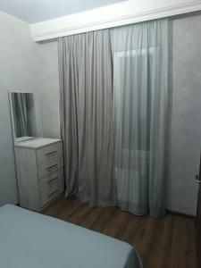 a bedroom with a bed and a dresser and a window at Palms in Kutaisi in Kutaisi