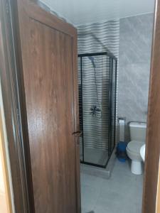a bathroom with a toilet and a wooden door at Palms in Kutaisi in Kutaisi