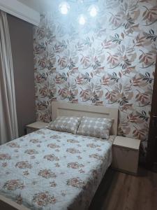 a bedroom with a bed with a floral wallpaper at Palms in Kutaisi in Kutaisi
