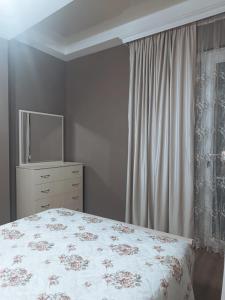a bedroom with a bed and a dresser with a television at Palms in Kutaisi in Kutaisi