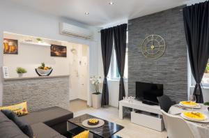 Apartment Porat في دوبروفنيك: غرفة معيشة مع أريكة وتلفزيون