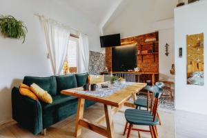 - un salon avec un canapé vert et une table en bois dans l'établissement Siedlisko Farmhouse, à Okszów