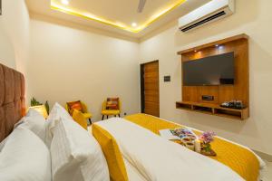 - une chambre avec un lit et une télévision à écran plat dans l'établissement ArtBuzz Jaipur, à Jaipur