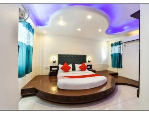 アーメダバードにあるHotel Grand Apple, Ahmedabadのベッドルーム1室(大型ベッド1台、赤い枕付)
