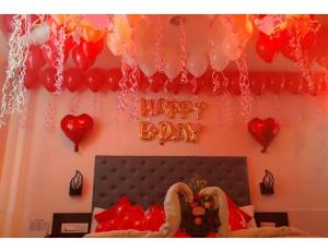 a room with a bed with hearts and a happy birthday sign at Hotel Grand Apple, Ahmedabad in Ahmedabad