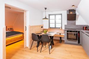 cocina y comedor con mesa y sillas en Zugspitze Apartment Sonn.Schein en Kurort Altenberg