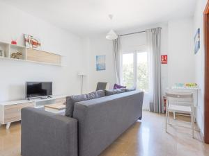 uma sala de estar com um sofá e uma televisão em Alcalá del Rio! bajo A em Alcalá del Río