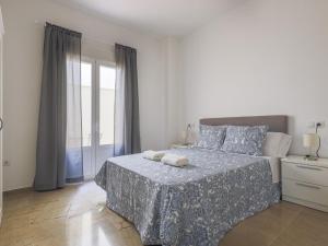 a white bedroom with a bed and a window at Alcalá del Rio! bajo A in Alcalá del Río