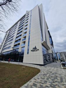 un gran edificio con un cartel en el costado en TOMAS LUX APARTMENTS, en Banja Luka