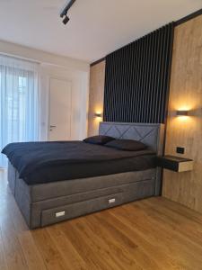 1 dormitorio con 1 cama grande y cabecero grande en TOMAS LUX APARTMENTS, en Banja Luka