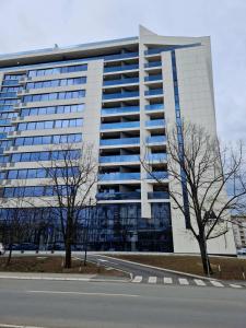 un gran edificio blanco con una carretera delante en TOMAS LUX APARTMENTS, en Banja Luka