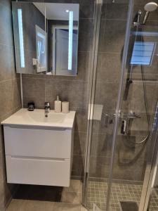 a bathroom with a white sink and a shower at Domki letniskowe bez zwierząt in Międzyzdroje +39 photos