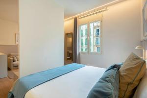 Fisa Rentals Ramblas Apartments tesisinde bir odada yatak veya yataklar