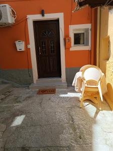 a chair sitting outside of a house with a door at Newly renovated apartment next to the port in Corfu Town