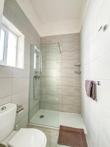 a white bathroom with a shower and a toilet at First floor 2 bedroom Modern Apartment in Gzira 3 in Il-Gżira
