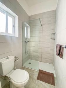 a white bathroom with a toilet and a shower at First floor 2 bedroom Modern Apartment in Gzira 3 in Il-Gżira