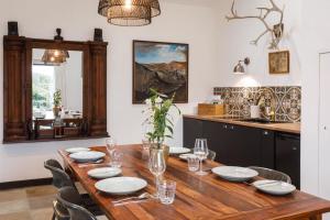 a dining room with a wooden table with chairs at Stylish Cottage in the Pewsey Vale in Marlborough