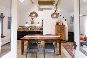 a kitchen and dining room with a wooden table and chairs at Stylish Cottage in the Pewsey Vale in Marlborough +35 photos