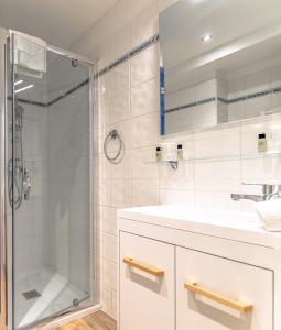 W łazience znajduje się prysznic i umywalka. w obiekcie Hotel Provencal w miejscowości Saint-Raphaël