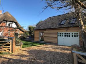 a house with a garage and a barn at Stylish Cottage in the Pewsey Vale in Marlborough
