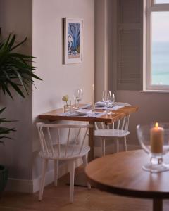 a table with two chairs and a table with wine glasses at Boskerris Hotel in St Ives