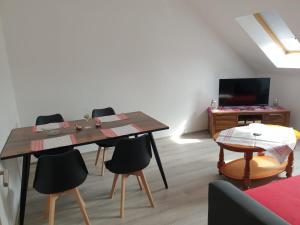 - un salon avec une table, des chaises et une télévision dans l'établissement Ferienwohnung 6 - Gourmetzimmer, à Bestensee