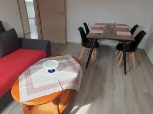 Cette chambre comprend une table, un canapé, une table et des chaises. dans l'établissement Ferienwohnung 6 - Gourmetzimmer, à Bestensee