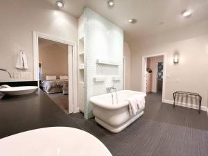 uma casa de banho branca com uma banheira e um lavatório em Modern Castle with Kitchen Hot Tub, Cafe, Office em San José