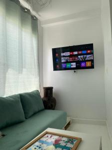 a living room with a green couch and a flat screen tv at Appartement a ksar SGHIR en face du terminal passagers de Ferry port Tanger Med in Ksar es Sghir