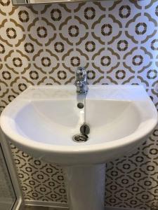 a white sink with a faucet in a bathroom at Sterlochy lodge in Boat of Garten